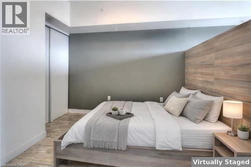 Bedroom with an accent wall, wood walls, wood finished floors, and a closet - 257 Hemlock Street Unit# 607, Waterloo, ON - Indoor Photo Showing Bedroom