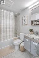 Bathroom with vanity, shower / bath combination with curtain, and light tile patterned flooring - 