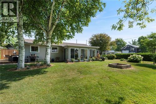 Rear view of property with board and batten siding and a sunroom - 181 Cedar Drive, Turkey Point, ON - Outdoor