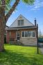 Bungalow-style home featuring a front yard, a chimney, stone siding, and a shingled roof - 226 Auburn Avenue, Hamilton, ON  - Outdoor 