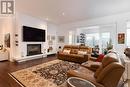 Fireplace + open to den/solarium - 401 - 77 Yates Street, St. Catharines (Downtown), ON  - Indoor Photo Showing Living Room With Fireplace 