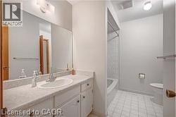 Bathroom featuring vanity, light tile patterned floors, and  shower combination - 