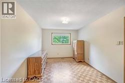 Original bedroom featuring parquet floors and a textured ceiling - 