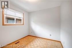 Spare room featuring parquet floors and baseboards - 