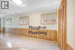 Original room featuring wainscoting, wood walls, and a textured ceiling - 