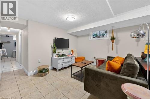 Living room with a textured ceiling and light tile patterned flooring - 22 Woodside Drive, Hamilton, ON - Indoor