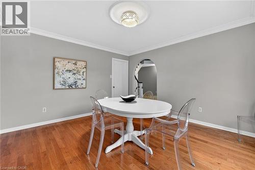 Dining area with ornamental molding, light wood-type flooring, and arched walkways - 22 Woodside Drive, Hamilton, ON - Indoor Photo Showing Dining Room