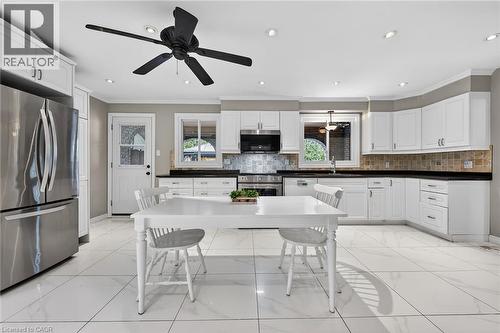 Kitchen featuring stainless steel appliances, dark countertops, white cabinets, ceiling fan, and ornamental molding - 22 Woodside Drive, Hamilton, ON - Indoor Photo Showing Kitchen With Upgraded Kitchen