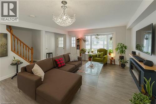 Living room featuring wood finished floors, hanging lights, and a textured ceiling - 988 Prosperity Court, London, ON - Indoor Photo Showing Living Room