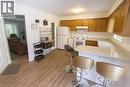 Kitchen with healthy amount of natural light, a kitchen bar, white appliances, and a peninsula - 988 Prosperity Court, London, ON  - Indoor Photo Showing Kitchen 