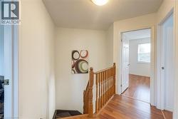 Corridor featuring an upstairs landing, wood finished floors, and a textured ceiling - 