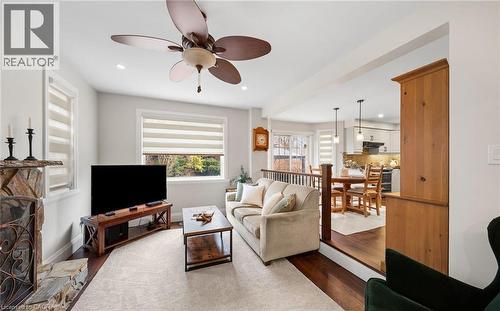 Living room with dark wood-style flooring, a ceiling fan, recessed lighting, and a stone fireplace - 4516 Gullfoot Circle, Mississauga, ON - Indoor Photo Showing Living Room With Fireplace