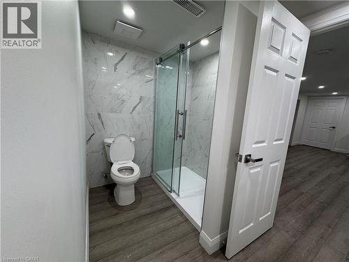 Bathroom with dark wood-style flooring and a marble finish shower - 18 Cyprus Drive Unit# Lower, Kitchener, ON - Indoor Photo Showing Bathroom