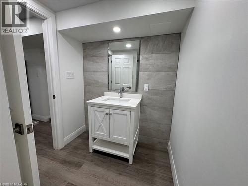 Bathroom featuring vanity, tile walls, dark wood-style flooring, and recessed lighting - 18 Cyprus Drive Unit# Lower, Kitchener, ON - Indoor Photo Showing Bathroom