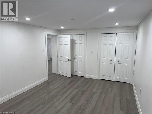 Unfurnished bedroom with multiple closets, dark wood-type flooring, and recessed lighting - 18 Cyprus Drive Unit# Lower, Kitchener, ON - Indoor Photo Showing Other Room