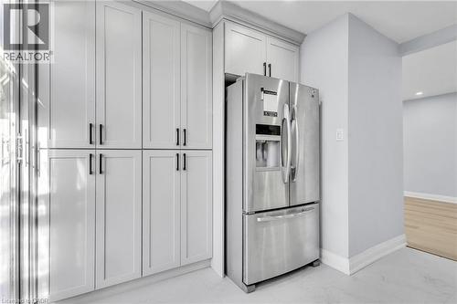 Kitchen with stainless steel refrigerator with ice dispenser, light marble finish floors, and recessed lighting - 84 Avalon Place, Kitchener, ON - Indoor