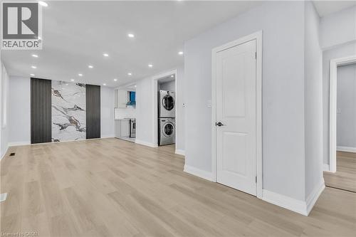 Unfurnished living room featuring recessed lighting, light wood-type flooring, and stacked washer / dryer - 84 Avalon Place, Kitchener, ON - Indoor Photo Showing Other Room