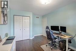 Office area featuring a textured ceiling and dark wood-style flooring - 