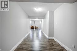 Hallway featuring dark wood-type flooring and baseboards - 