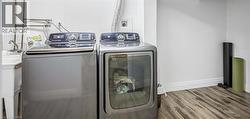 Laundry room with wood finished floors and separate washer and dryer - 