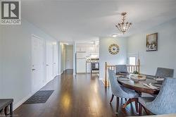 Dining area with dark wood-type flooring, a chandelier, and a ceiling fan - 