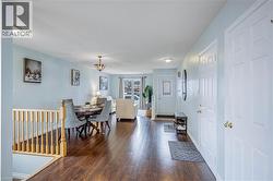 Dining room featuring dark wood-type flooring and hanging lights - 