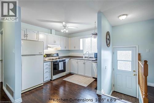 Kitchen featuring white appliances, white cabinetry, dark wood-style flooring, and a ceiling fan - 8 Brantdale Avenue, Hamilton, ON - Indoor Photo Showing Kitchen