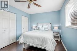 Bedroom with multiple closets, dark wood finished floors, and ceiling fan - 