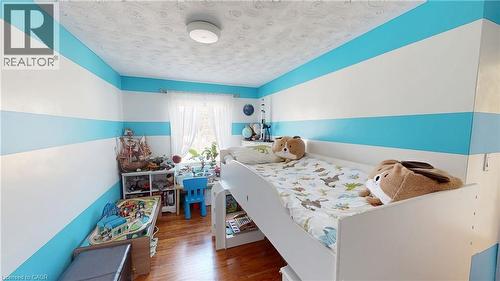 Bedroom featuring wood finished floors and a textured ceiling - 10 Armstrong Avenue, Hamilton, ON - Indoor