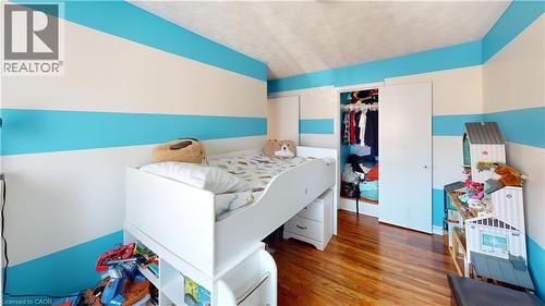Bedroom with wood finished floors, a closet, and a textured ceiling - 10 Armstrong Avenue, Hamilton, ON - Indoor Photo Showing Bedroom