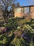 Landscaped front yard featuring a variety of blooming spring flowers, mature trees, and natural rock accents - 222 Greencedar Drive, Hamilton, ON  - Outdoor 