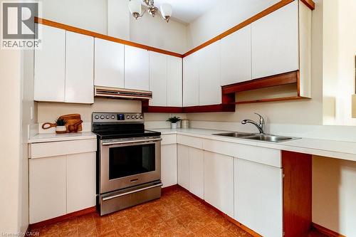 Kitchen with electric stove, light countertops, and white cabinets - 218 Bay Street S, Hamilton, ON 