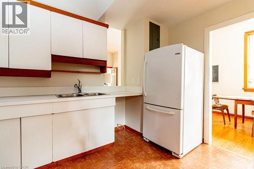 Kitchen featuring freestanding refrigerator, light countertops, white cabinetry, and light floors - 218 Bay Street S, Hamilton, ON 