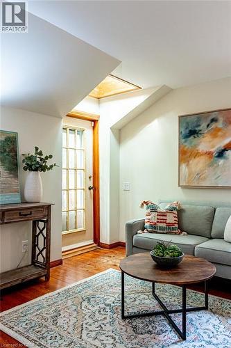 Living room with light wood-type flooring and baseboards - 218 Bay Street S, Hamilton, ON 