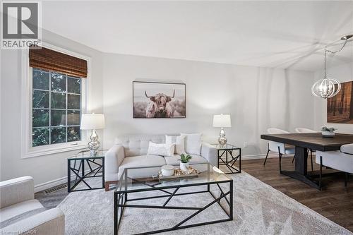Living area featuring wood finished floors and hanging lights - 68 Newman Drive, Cambridge, ON - Indoor Photo Showing Living Room