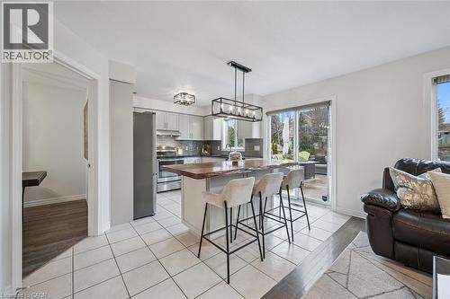 Kitchen featuring a kitchen bar, stainless steel appliances, a kitchen island, tasteful backsplash, and open floor plan - 68 Newman Drive, Cambridge, ON - Indoor