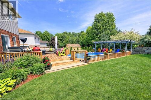 View of yard with an outdoor pool, a wooden deck, and a storage unit - 68 Newman Drive, Cambridge, ON - Outdoor With Deck Patio Veranda