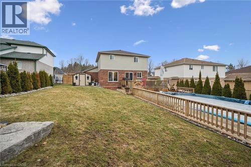 Rear view of property featuring a wooden deck, a fenced backyard, a storage unit, a residential view, and brick siding - 68 Newman Drive, Cambridge, ON - Outdoor With Backyard With Exterior