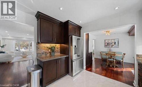 Kitchen with dark wood-style flooring, dark wood finish cabinetry, high end refrigerator, recessed lighting, and backsplash - 1550 Woodeden Drive, Mississauga, ON - Indoor