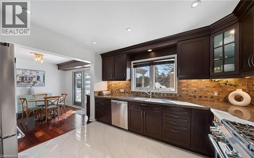 Kitchen featuring dark wood finish cabinets, stainless steel appliances, healthy amount of natural light, and dark stone countertops - 1550 Woodeden Drive, Mississauga, ON - Indoor Photo Showing Kitchen With Upgraded Kitchen
