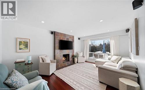 Living room with dark wood-style floors, a tile fireplace, and recessed lighting - 1550 Woodeden Drive, Mississauga, ON - Indoor Photo Showing Living Room With Fireplace