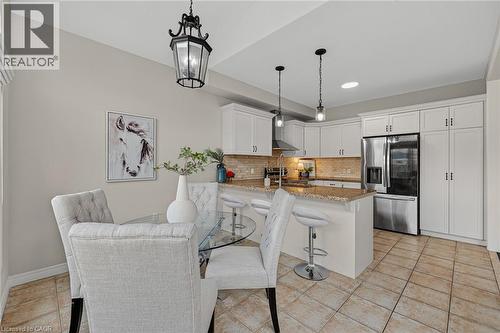 Dining space featuring light tile patterned floors and a chandelier - 100 Garinger Crescent, Binbrook, ON - Indoor Photo Showing Kitchen With Stainless Steel Kitchen With Upgraded Kitchen