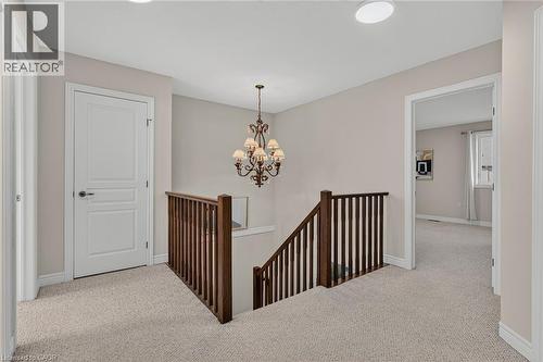 Hallway featuring light carpet, an upstairs landing, and hanging lights - 100 Garinger Crescent, Binbrook, ON - Indoor Photo Showing Other Room