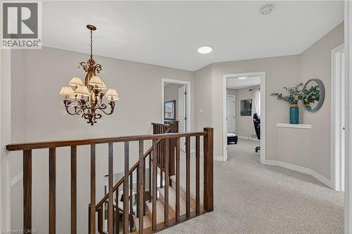 Hall with an upstairs landing, a chandelier, and light carpet - 100 Garinger Crescent, Binbrook, ON - Indoor Photo Showing Other Room
