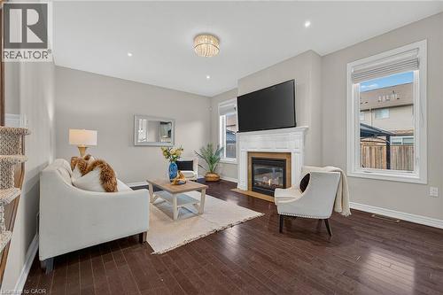 Living area with dark wood finished floors and a fireplace with flush hearth - 100 Garinger Crescent, Binbrook, ON - Indoor Photo Showing Living Room With Fireplace