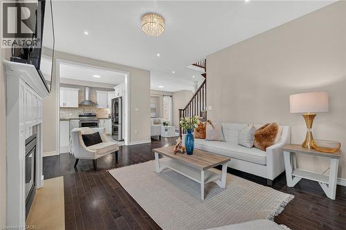 Living room featuring dark wood-type flooring, recessed lighting, and a fireplace - 100 Garinger Crescent, Binbrook, ON - Indoor Photo Showing Living Room