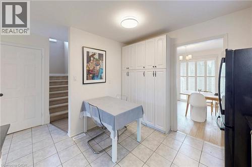Dining area featuring stairs and light tile patterned flooring - 62 Como Place, Hamilton, ON - Indoor Photo Showing Other Room