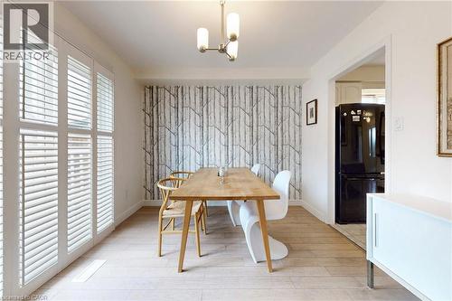 Dining room with light wood-style flooring and hanging lights - 62 Como Place, Hamilton, ON - Indoor Photo Showing Dining Room