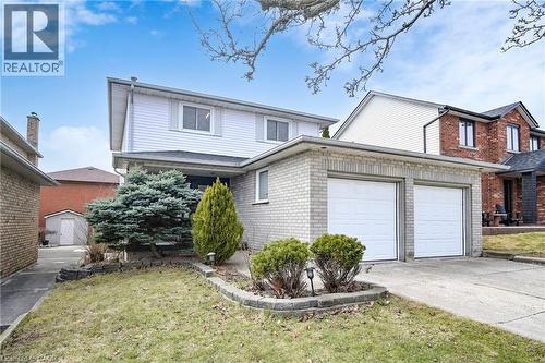 Traditional home featuring brick siding, a garage, driveway, and a front yard - 62 Como Place, Hamilton, ON - Outdoor