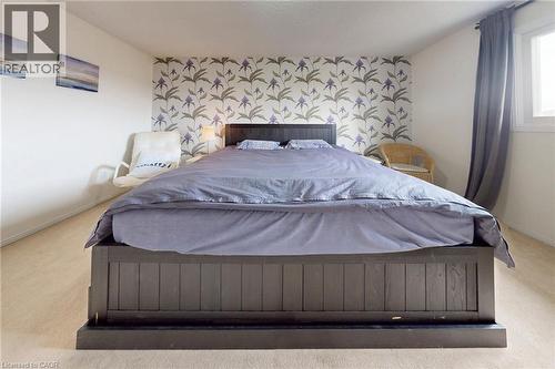 Bedroom with light colored carpet and an accent wall - 62 Como Place, Hamilton, ON - Indoor Photo Showing Bedroom